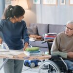 Volunteer helping to senior man with chores